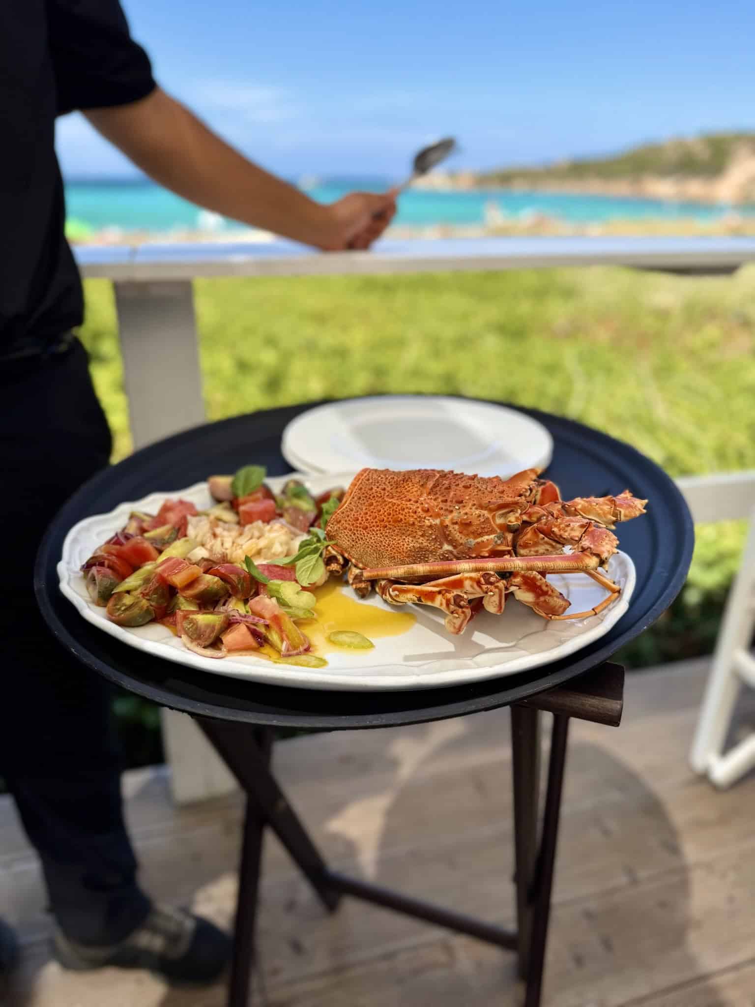 Fresh lobster seafood dish served outdoors with seaside view at Pikasea.