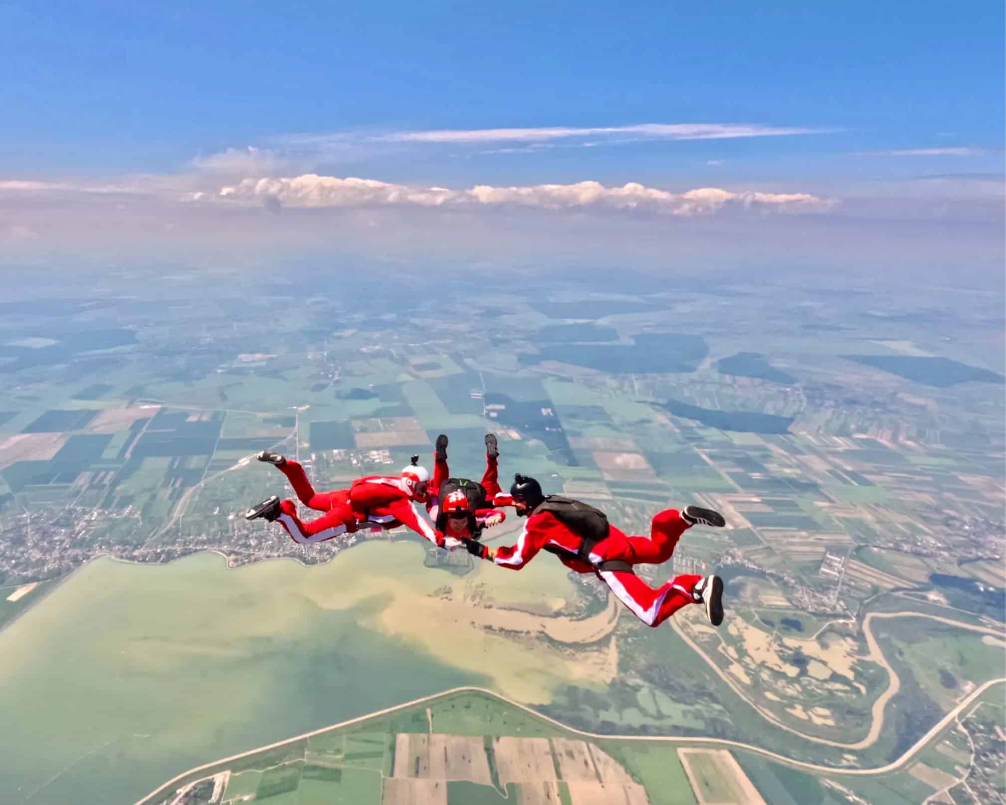 Adventurers skydiving over scenic landscape during Sky & Sea Fest 2026.