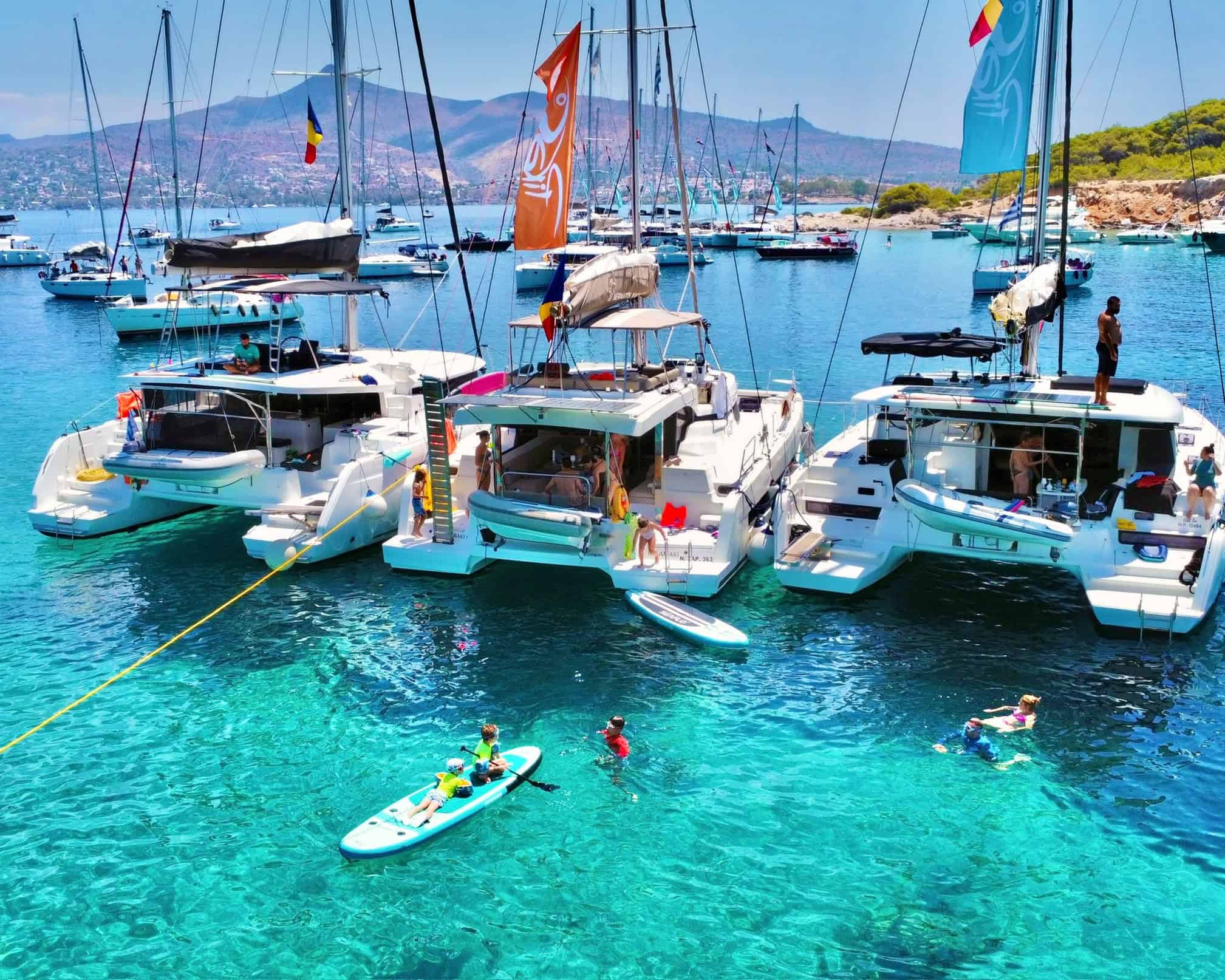 Luxury yachts and water sports at Sky & Sea Fest 2026, Pikasea & TNT event. Enjoy sailing, paddleboarding, and swimming in crystal-clear waters with scenic mountain views in the background.